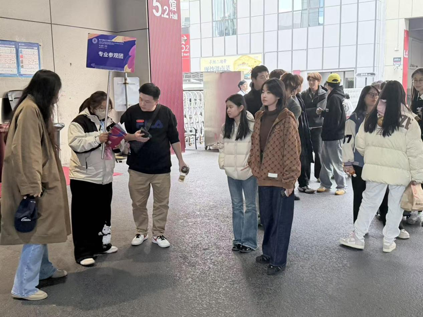 我校两位老师和展会工作人员带领学生参观